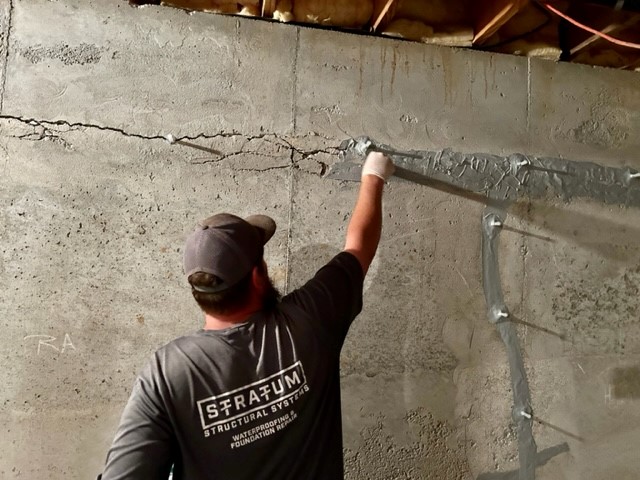 Technician repairing a foundation crack with structural repair material in Fort Worth