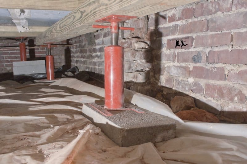Pier and beam foundation repair with adjustable steel jack supporting floor joist in a Fort Worth crawl space