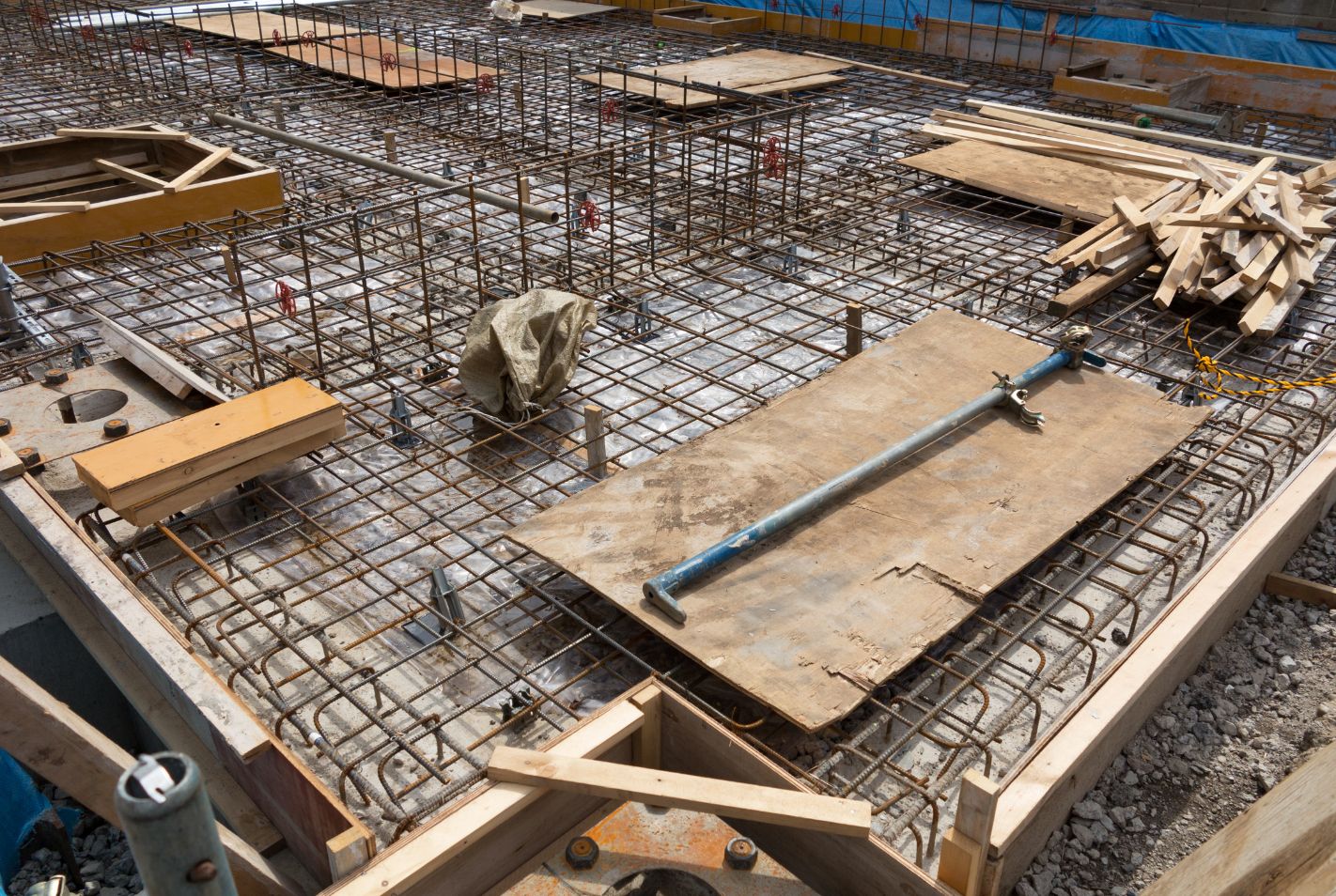 New slab foundation under construction with rebar grid and plumbing stub-outs, Fort Worth TX